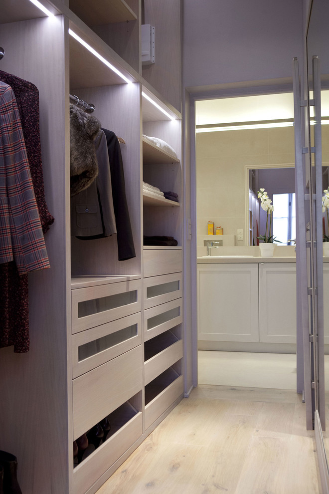 Cette image montre un petit dressing room design en bois clair pour une femme avec un placard sans porte, parquet clair et un sol marron.