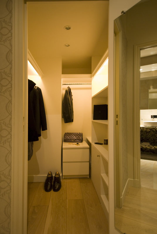 Immagine di un piccolo spazio per vestirsi unisex tradizionale con nessun'anta, ante bianche, parquet chiaro e pavimento marrone