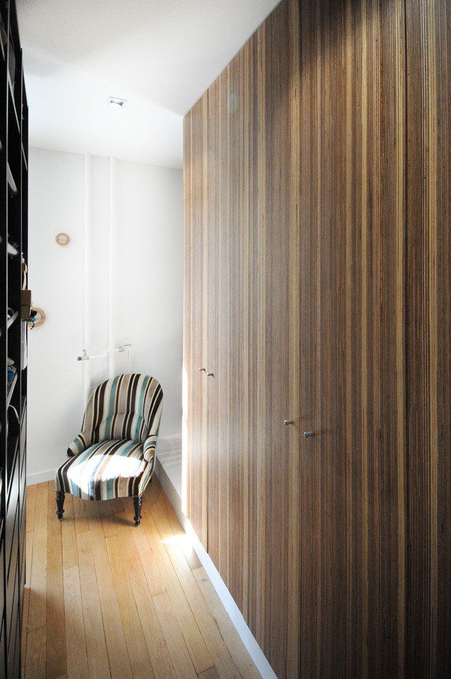 Imagen de armario y vestidor nórdico con suelo de madera clara