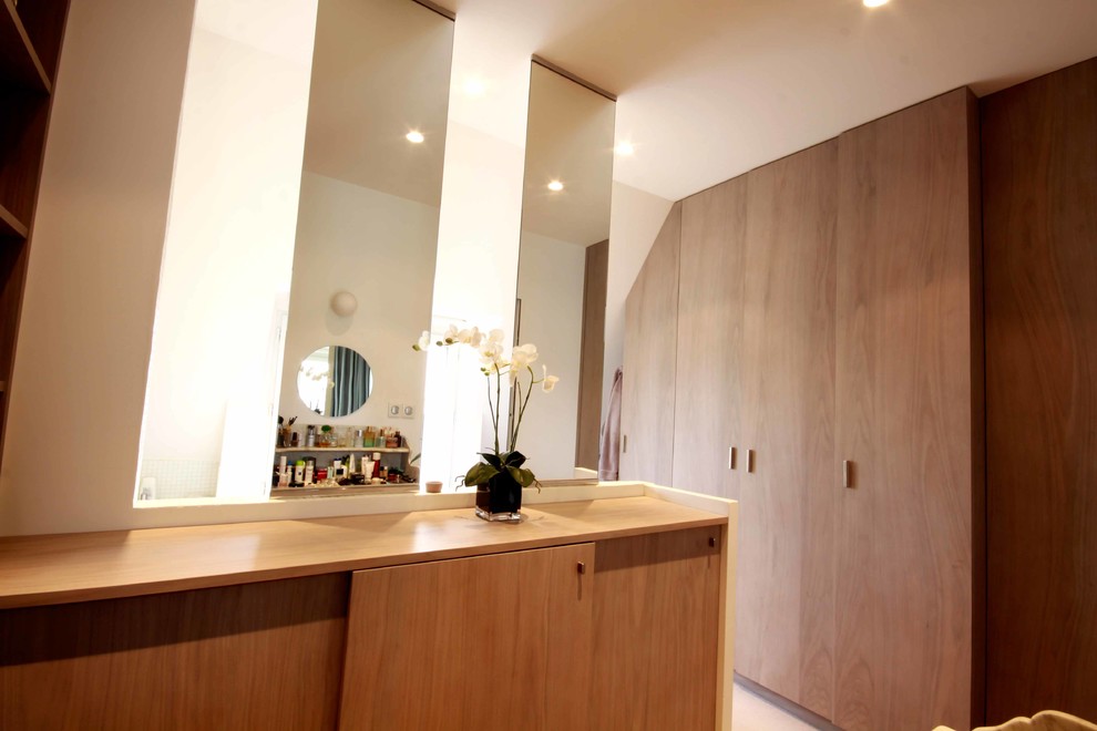 Idée de décoration pour un petit dressing room minimaliste neutre avec un placard sans porte, des portes de placard grises, moquette et un sol blanc.