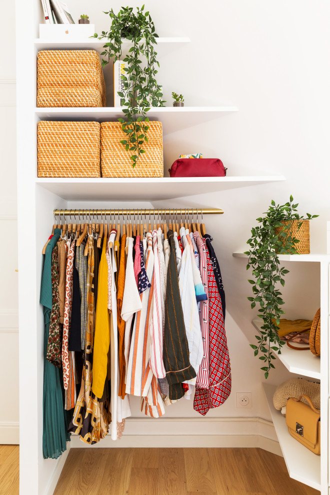 Aménagement d'un petit dressing romantique pour une femme avec un placard sans porte, des portes de placard blanches, parquet clair et un sol marron.