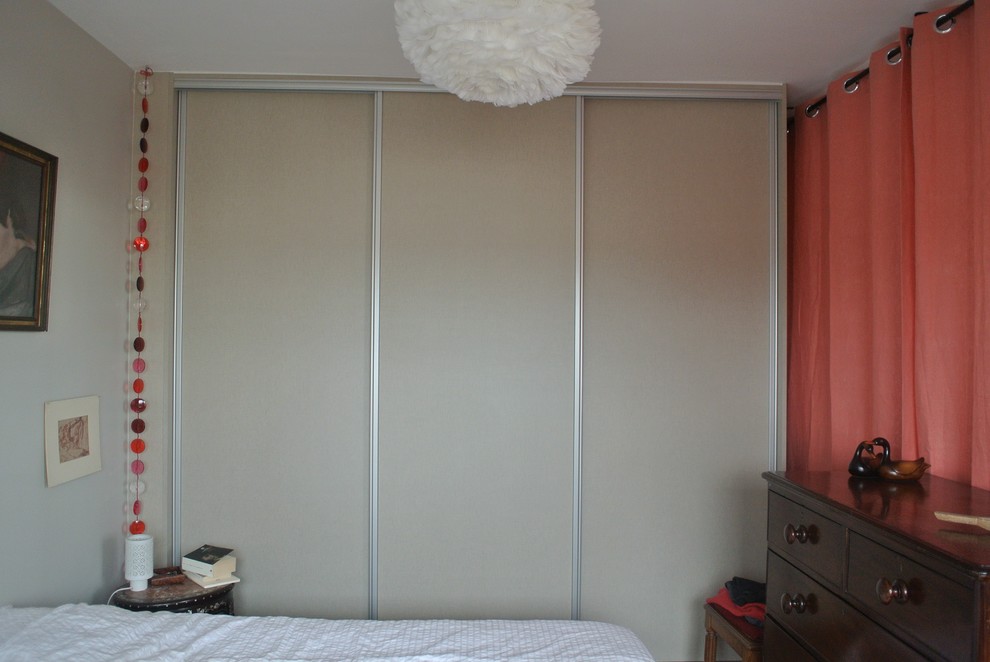 Idée de décoration pour un placard dressing bohème de taille moyenne et neutre avec un placard à porte affleurante et des portes de placard beiges.