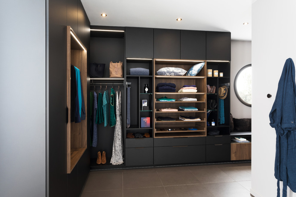 Пример оригинального дизайна: гардеробная комната в современном стиле с плоскими фасадами, черными фасадами и коричневым полом