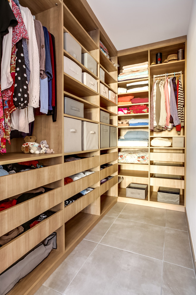 Imagen de armario vestidor unisex contemporáneo de tamaño medio con armarios abiertos, puertas de armario de madera clara y suelo de baldosas de cerámica