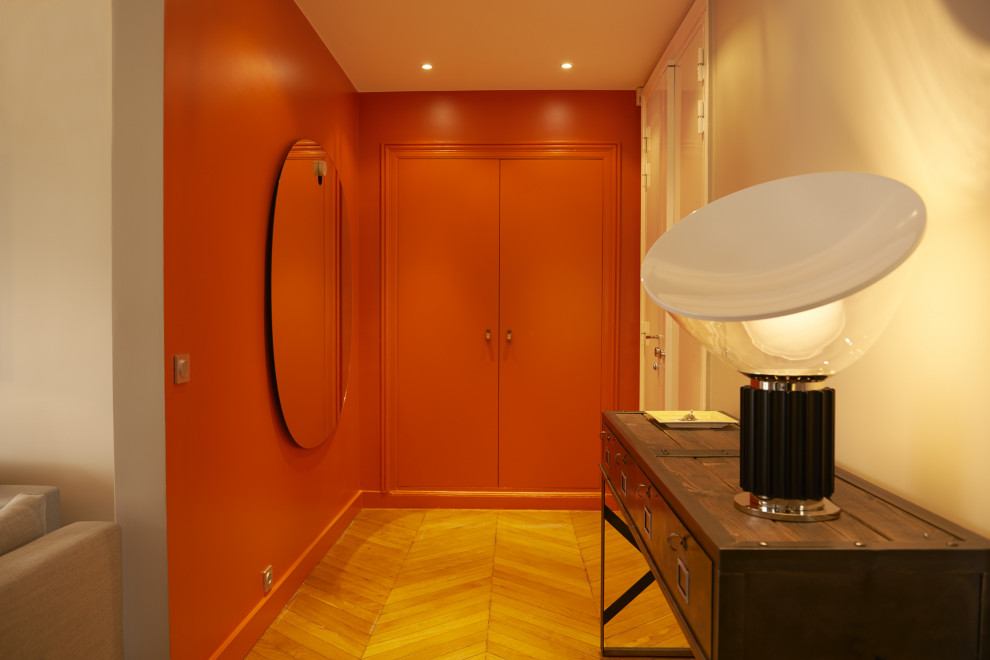 Свежая идея для дизайна: большая гардеробная комната унисекс в современном стиле с оранжевыми фасадами, светлым паркетным полом и коричневым полом - отличное фото интерьера