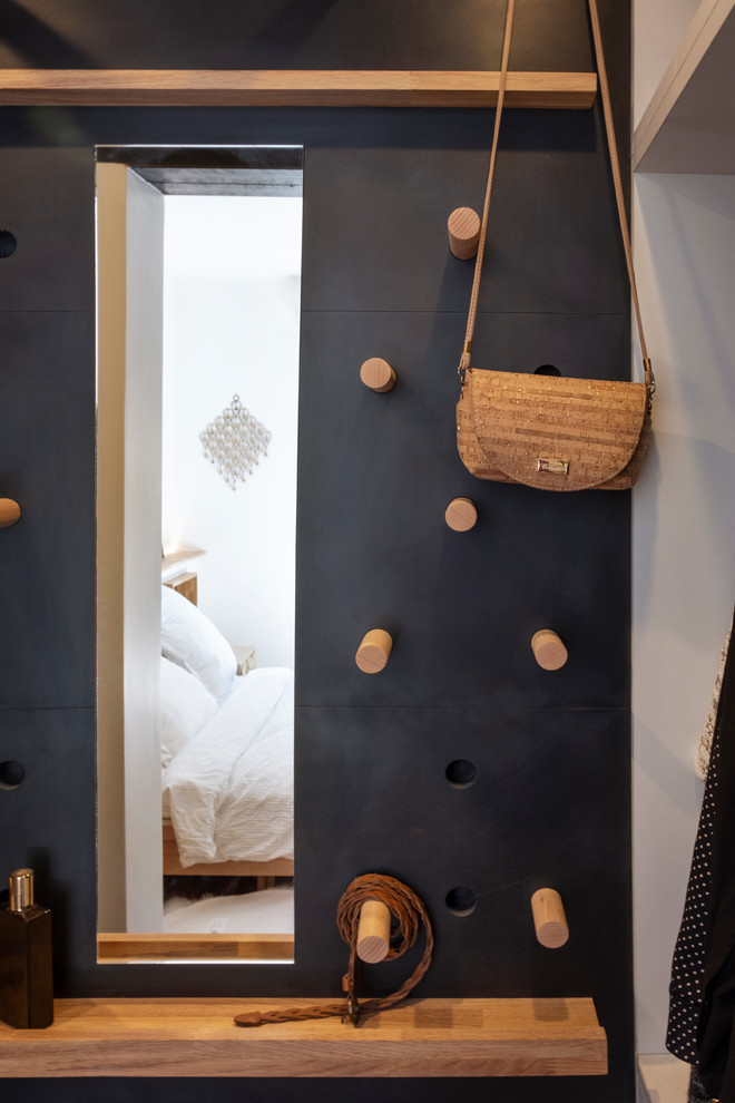 Aménagement d'un petit dressing room industriel en bois clair neutre avec un placard à porte persienne, parquet clair et un sol beige.