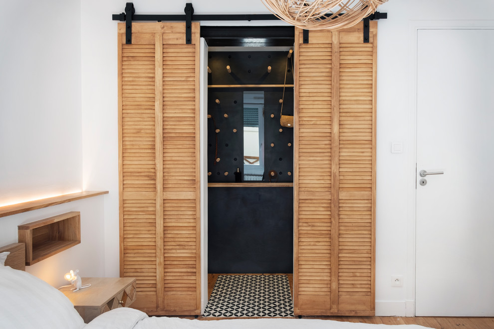 Immagine di un piccolo spazio per vestirsi unisex industriale con ante a persiana, ante in legno chiaro, parquet chiaro e pavimento beige