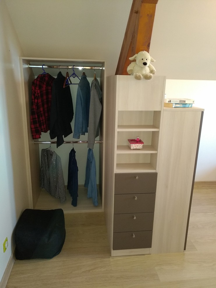 Imagen de armario vestidor unisex pequeño con armarios con paneles lisos, puertas de armario beige, suelo laminado y suelo gris