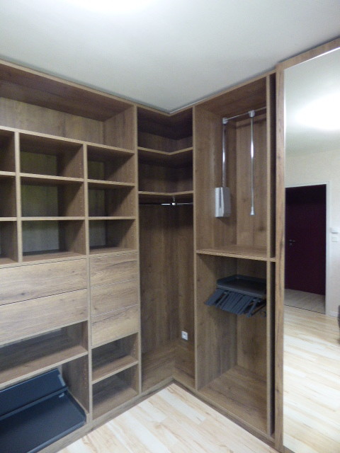 Cette photo montre un dressing room chic en bois foncé neutre avec un placard sans porte, sol en stratifié et un sol beige.