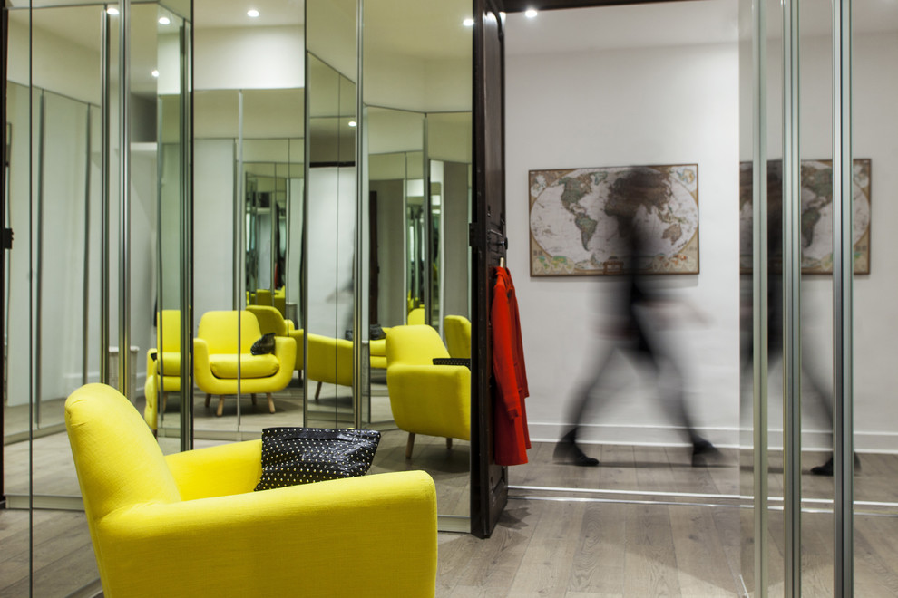 Aménagement d'un petit dressing room moderne pour une femme avec un placard à porte vitrée et parquet clair.