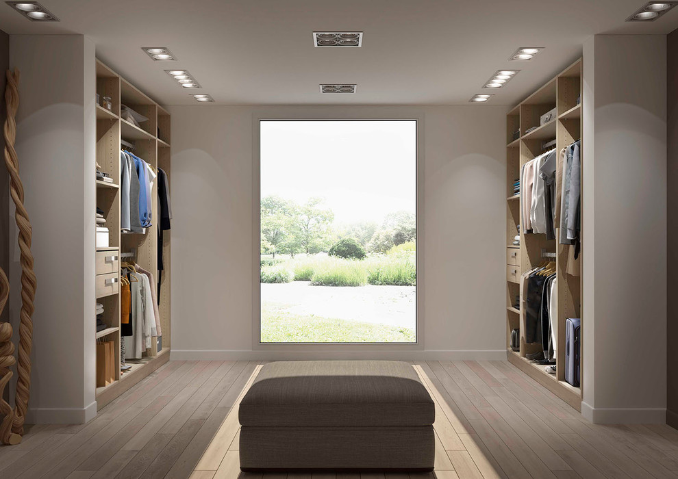 Cette image montre un grand dressing room nordique en bois clair neutre avec un placard sans porte et parquet clair.