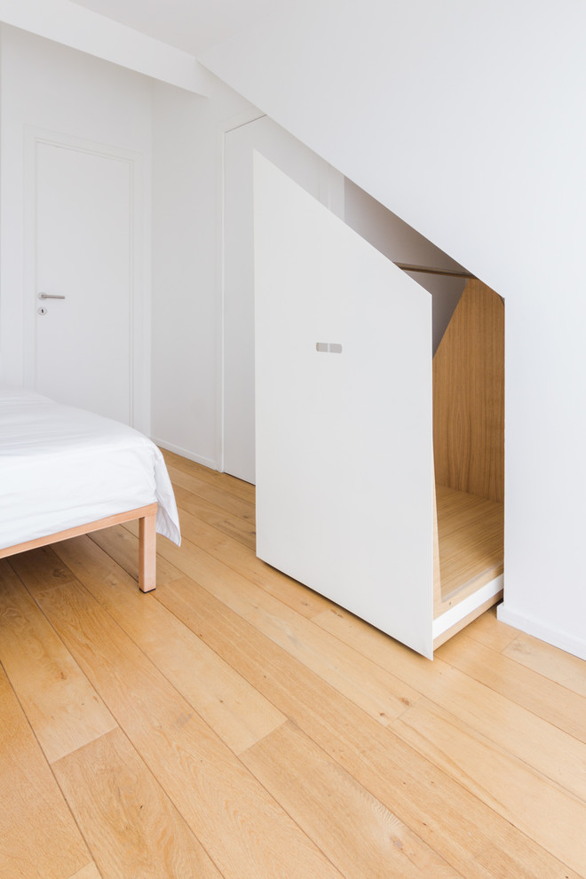 Ejemplo de armario unisex contemporáneo grande con armarios con rebordes decorativos, puertas de armario blancas, suelo de madera clara y suelo beige