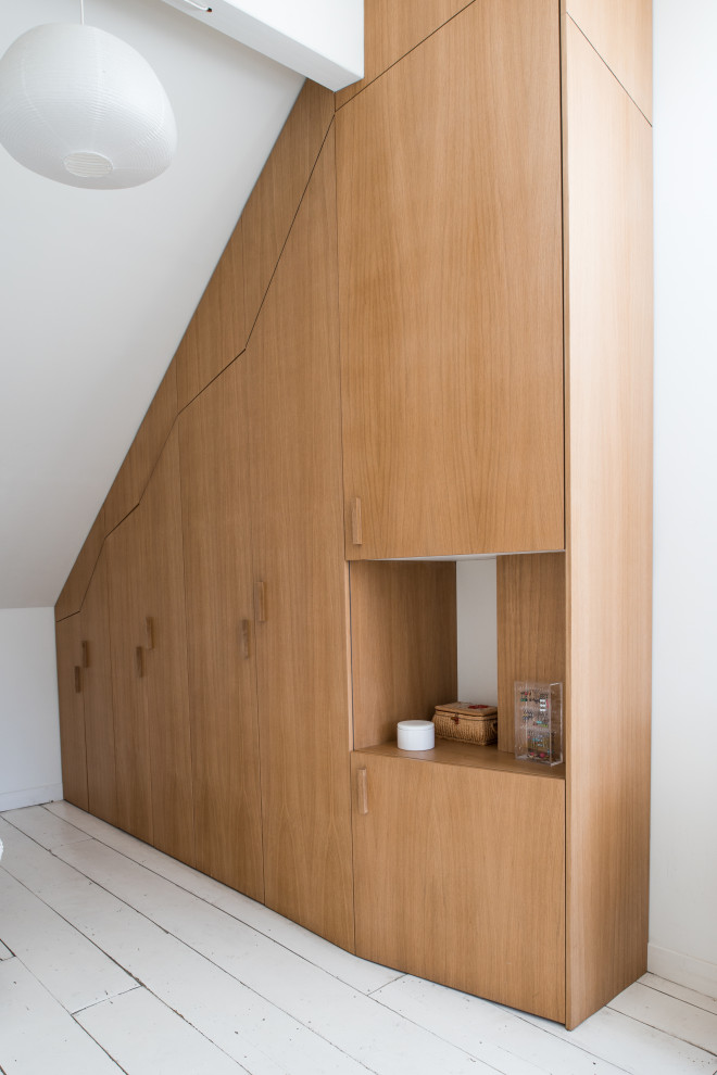 Immagine di un armadio o armadio a muro unisex nordico con ante in legno chiaro, pavimento in legno verniciato e pavimento bianco