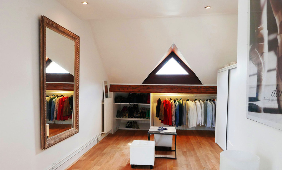 Example of a large transitional gender-neutral light wood floor dressing room design in Paris