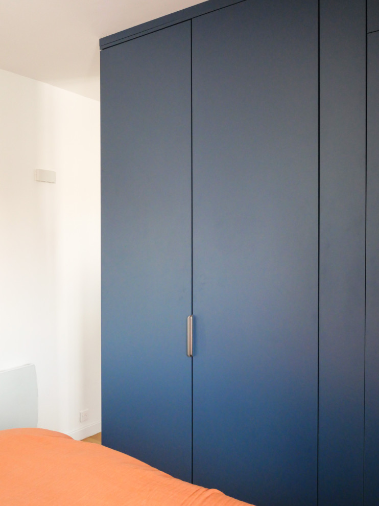 На фото: маленькая гардеробная комната унисекс в современном стиле с плоскими фасадами и синими фасадами для на участке и в саду