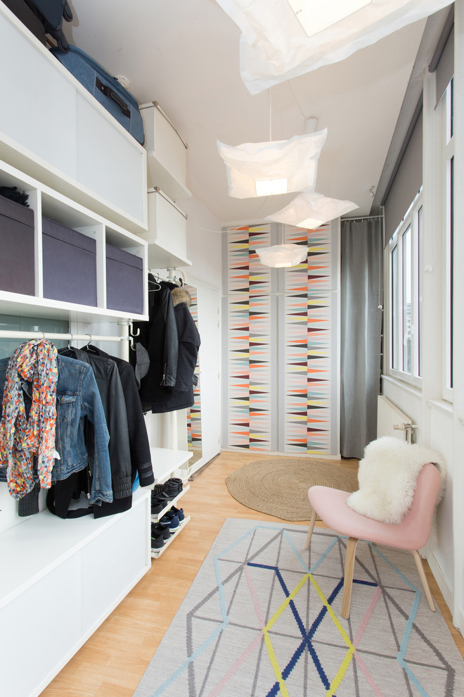 Mittelgroßes Nordisches Ankleidezimmer mit Ankleidebereich, weißen Schränken, hellem Holzboden und beigem Boden in Rennes