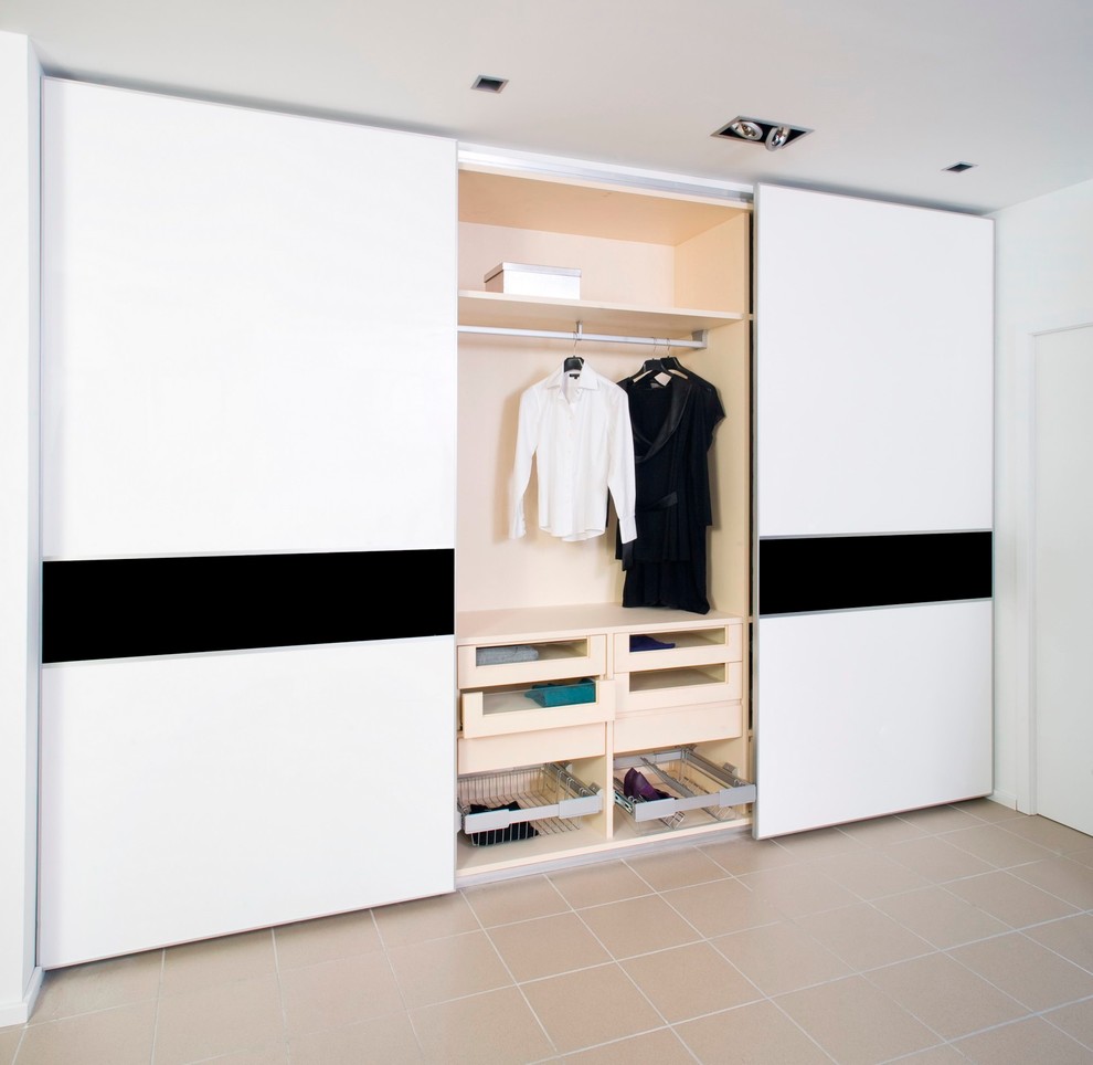 На фото: шкаф в нише среднего размера, унисекс в стиле модернизм с белыми фасадами и полом из керамической плитки с