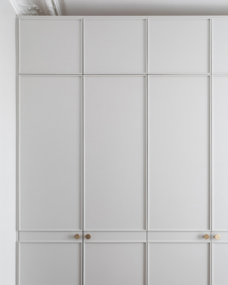 Diseño de armario unisex tradicional de tamaño medio con armarios con rebordes decorativos, puertas de armario grises y suelo de madera clara