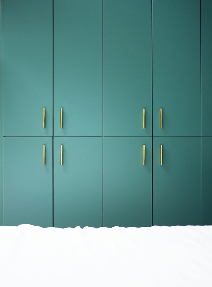 Cette photo montre un dressing moderne de taille moyenne et neutre avec un placard à porte affleurante, des portes de placard bleues, parquet clair et un sol beige.
