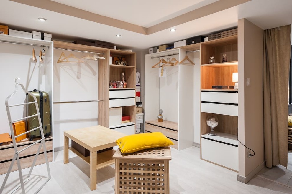 Imagen de armario vestidor unisex contemporáneo grande con armarios abiertos, puertas de armario de madera clara, suelo laminado y suelo beige