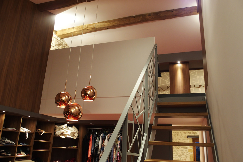 Idée de décoration pour un très grand dressing room design en bois brun neutre avec moquette et un sol rouge.