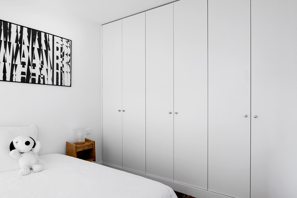 Immagine di un armadio o armadio a muro unisex contemporaneo di medie dimensioni con ante lisce, ante bianche, parquet chiaro e pavimento marrone