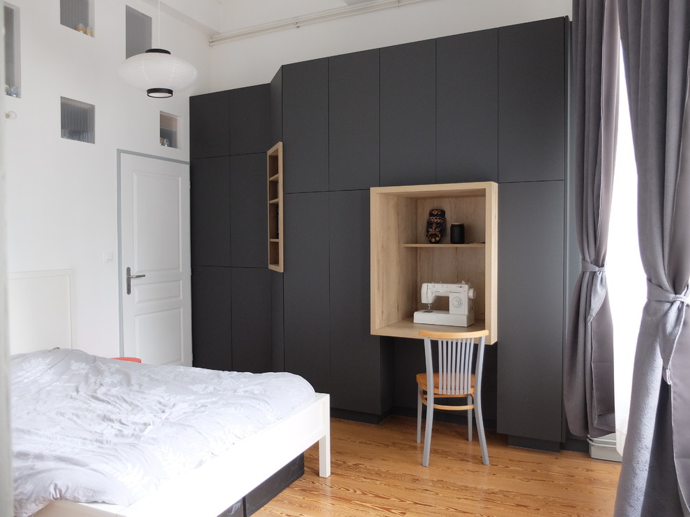Aménagement d'un placard dressing moderne de taille moyenne et neutre avec un sol en bois brun, un sol marron, un placard à porte plane et des portes de placard grises.