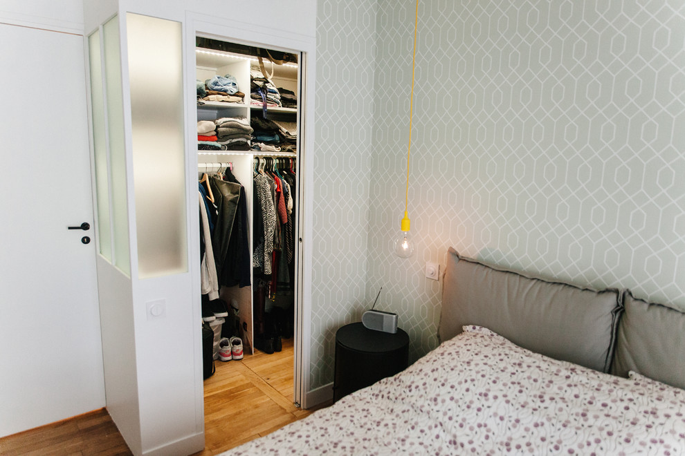 Ejemplo de vestidor de mujer minimalista de tamaño medio con armarios abiertos, puertas de armario blancas y suelo de madera clara