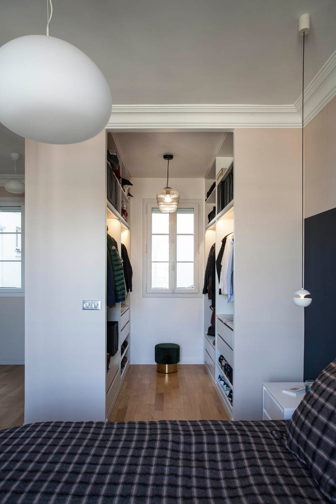 На фото: гардеробная комната унисекс в современном стиле с открытыми фасадами, белыми фасадами, паркетным полом среднего тона и коричневым полом с