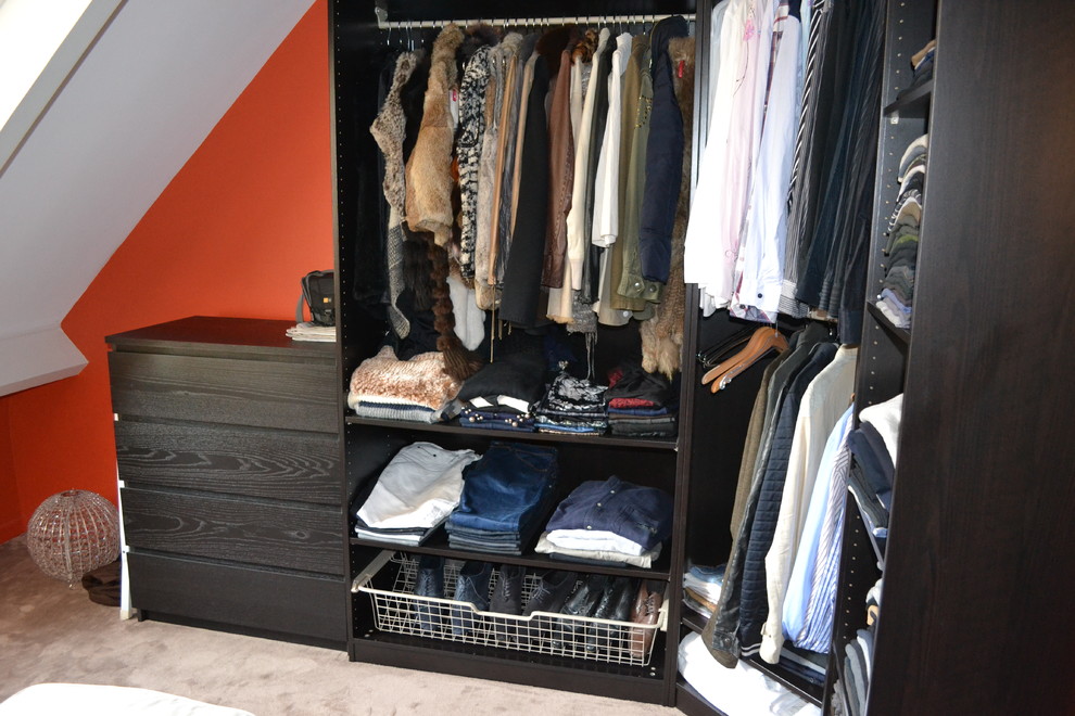 Modelo de armario vestidor de mujer actual de tamaño medio con armarios abiertos, puertas de armario de madera en tonos medios, moqueta y suelo gris