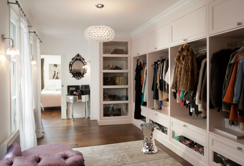 Ejemplo de vestidor de mujer clásico renovado grande con armarios abiertos, suelo de madera en tonos medios y puertas de armario blancas