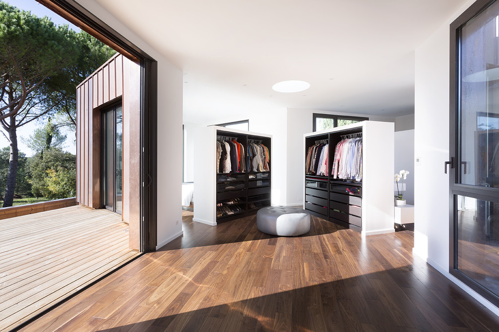 Idee per un grande spazio per vestirsi per uomo design con ante in legno bruno, pavimento marrone e parquet scuro