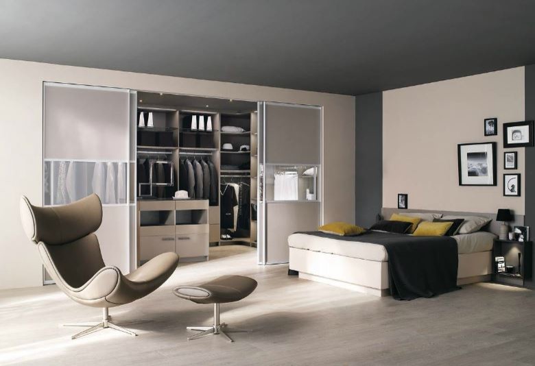 Cette image montre un grand dressing room design pour un homme avec un placard sans porte, des portes de placard grises et parquet clair.