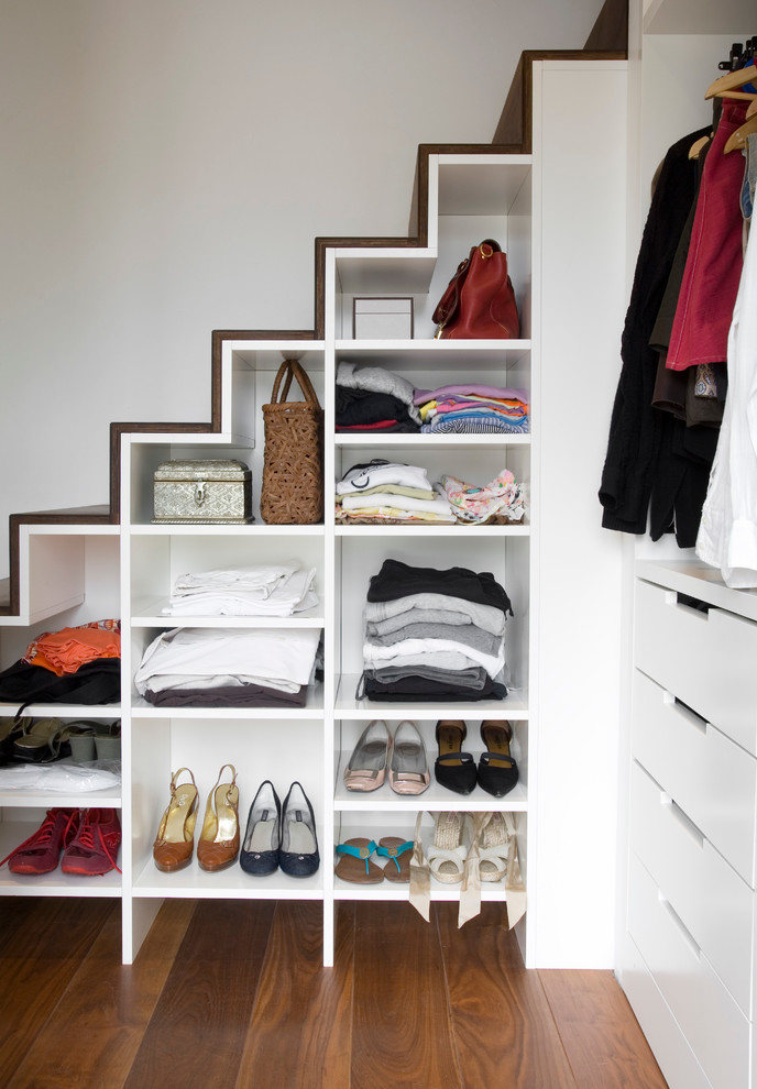 Inspiration for a medium sized contemporary standard wardrobe for women in Paris with open cabinets, white cabinets and medium hardwood flooring.