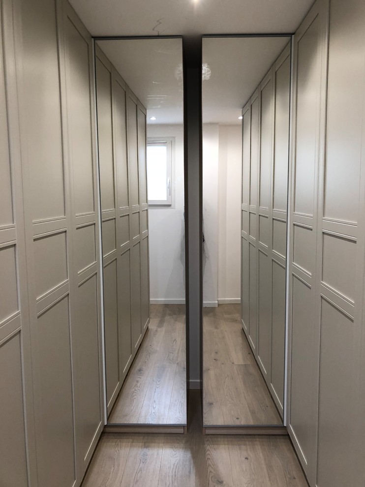 Cette photo montre un dressing room tendance de taille moyenne et neutre avec des portes de placard marrons, parquet foncé et un sol marron.