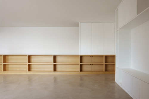 Exemple d'un grande dressing et rangement tendance en bois brun neutre avec un placard sans porte, sol en béton ciré et un sol beige.