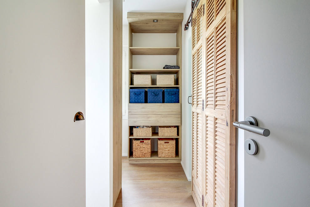 Idee per una cabina armadio unisex moderna di medie dimensioni con nessun'anta, ante in legno chiaro, parquet chiaro e pavimento beige