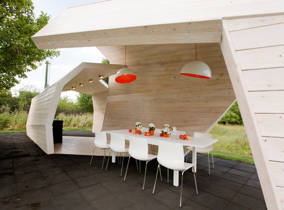 Réalisation d'une terrasse arrière design de taille moyenne avec une cuisine d'été et une extension de toiture.