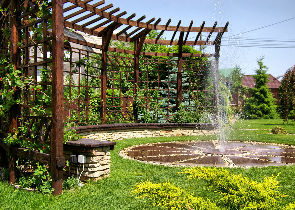 На фото: пергола во дворе частного дома в средиземноморском стиле с фонтаном с