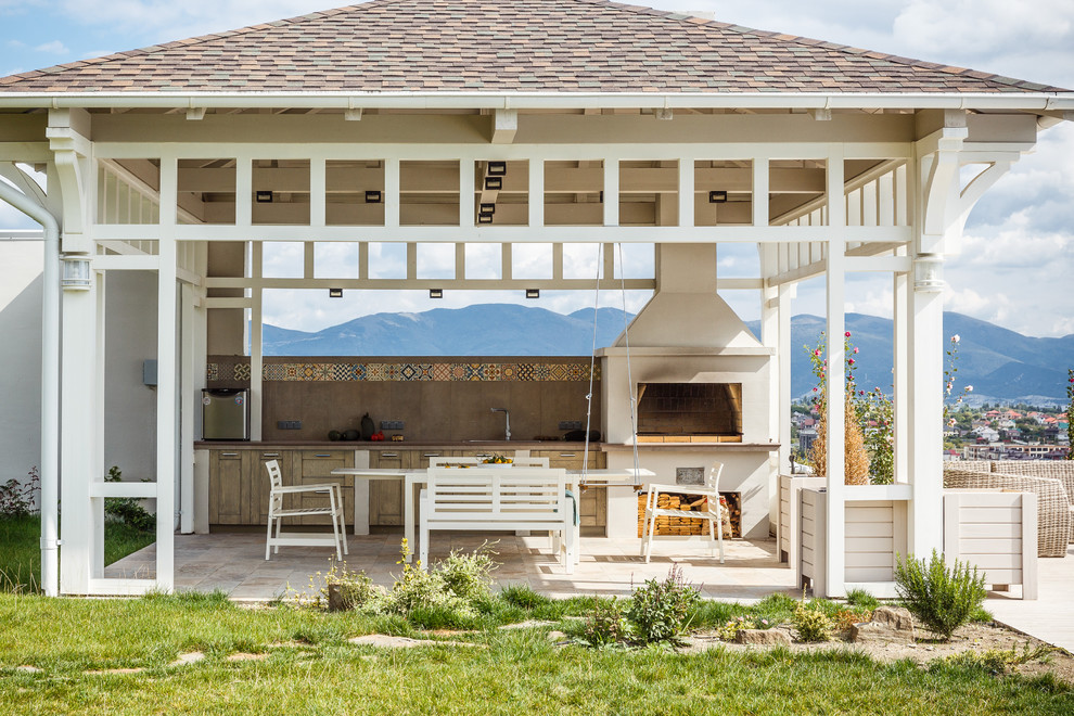 Immagine di un patio o portico country dietro casa con un gazebo o capanno e pavimentazioni in pietra naturale