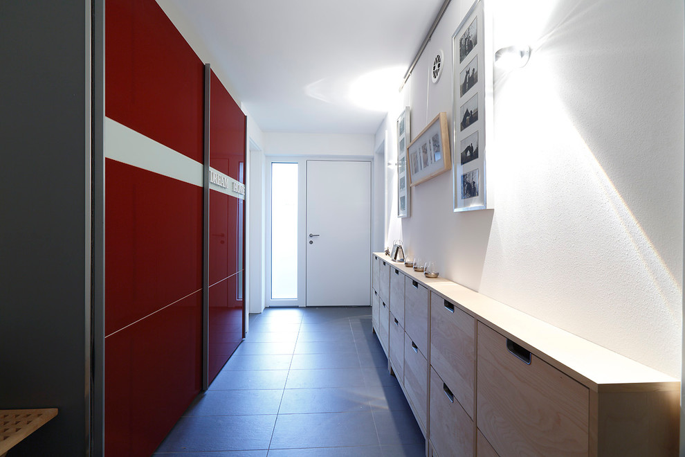 Cette photo montre une entrée tendance de taille moyenne avec un couloir, un mur blanc, une porte simple, une porte blanche et un sol en carrelage de porcelaine.