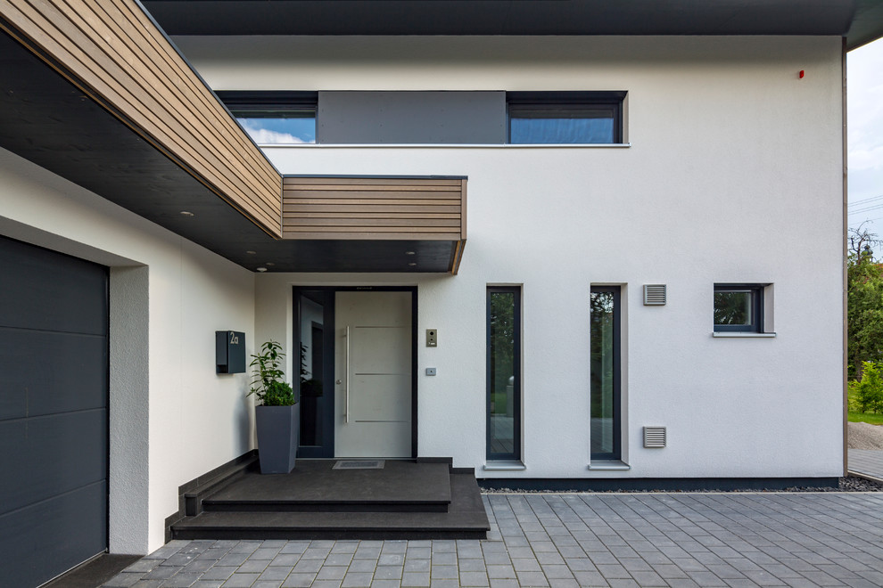 Große Moderne Haustür mit weißer Wandfarbe, Granitboden, Einzeltür, grauer Haustür und schwarzem Boden in München