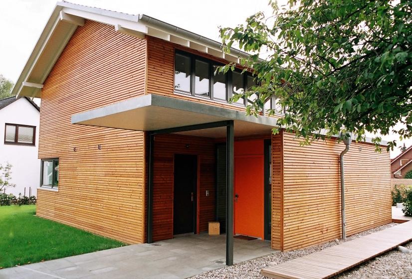 Modern inredning av en mycket stor ingång och ytterdörr, med bruna väggar, en enkeldörr och en orange dörr