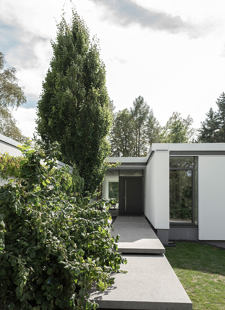 This is an example of a modern entrance in Frankfurt with white walls and a grey front door.