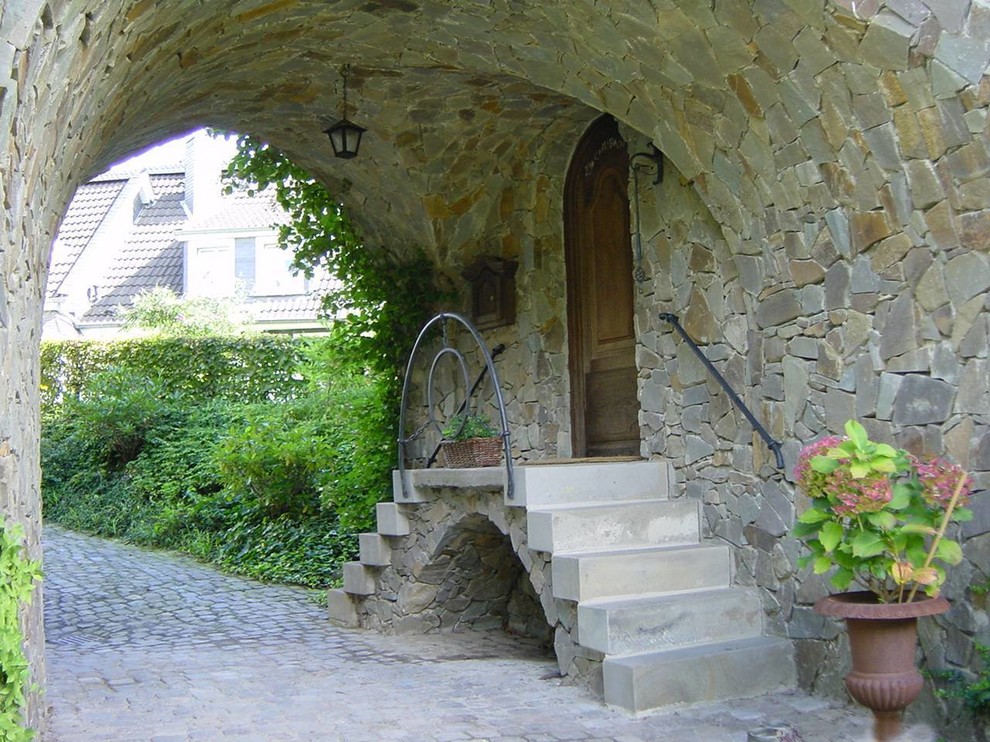 Esempio di una porta d'ingresso stile rurale di medie dimensioni con pareti multicolore, pavimento in granito, una porta singola, pavimento grigio e una porta marrone