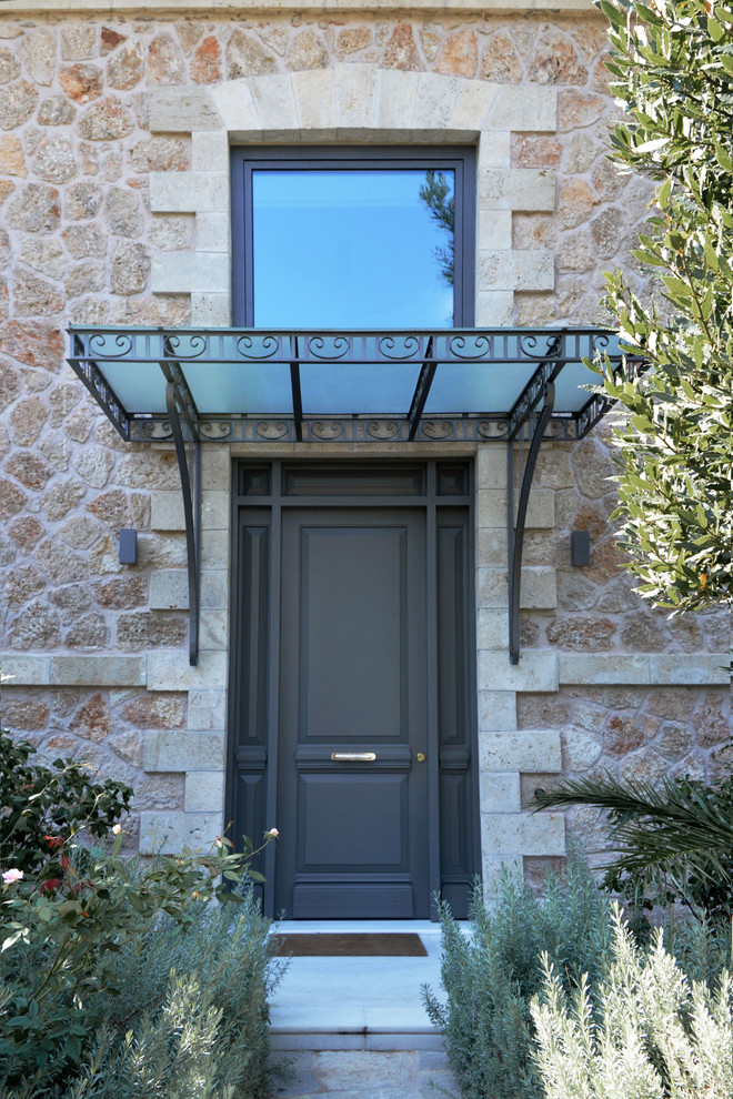 На фото: входная дверь в классическом стиле с бежевыми стенами, мраморным полом, черной входной дверью и белым полом