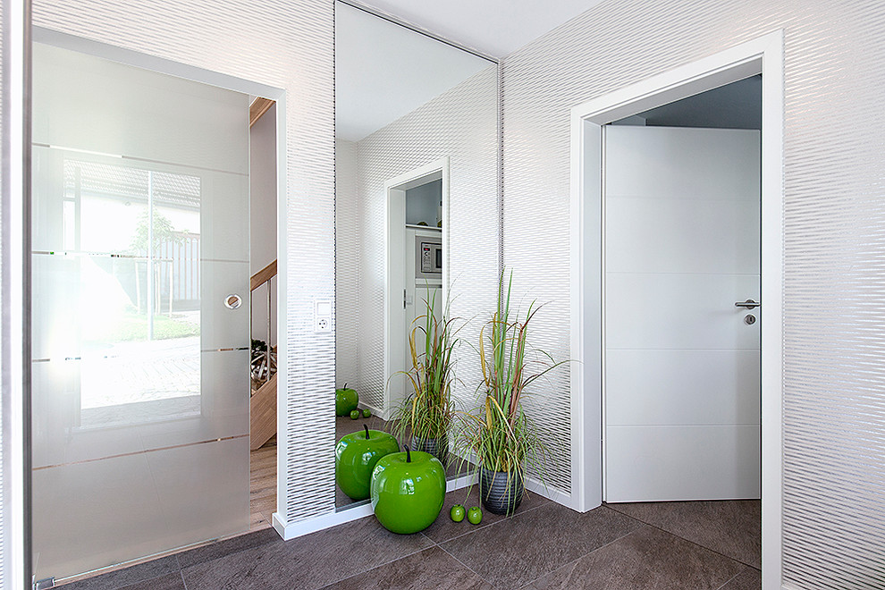 Foto på en mellanstor funkis farstu, med metallisk väggfärg, en enkeldörr, en vit dörr och betonggolv