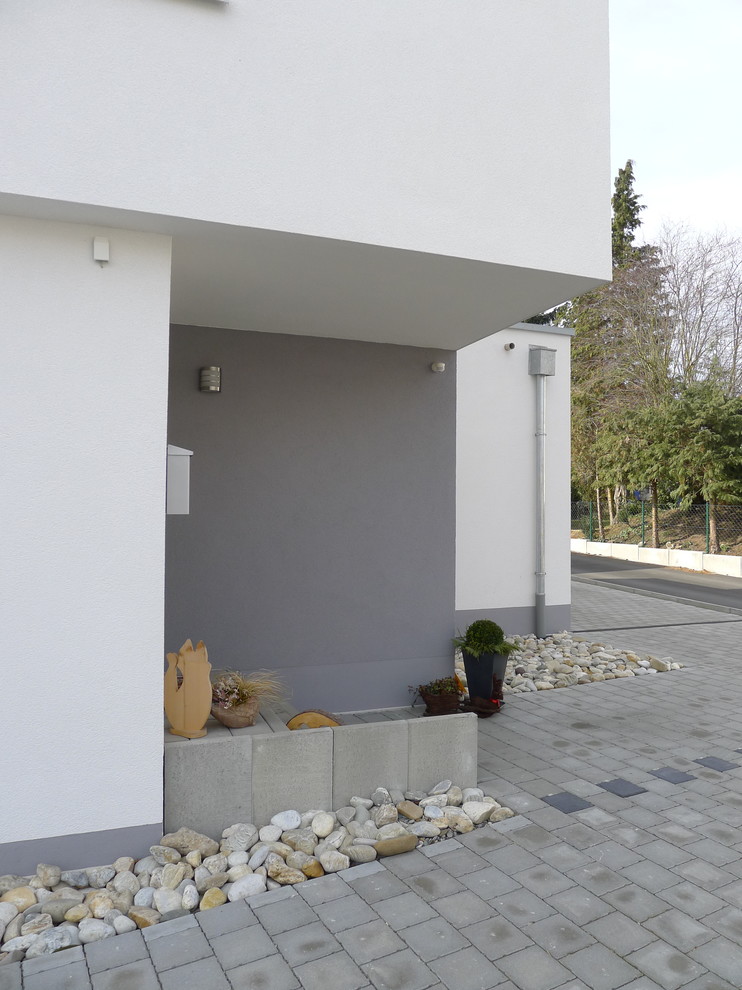 Idée de décoration pour une entrée minimaliste de taille moyenne avec un mur gris.