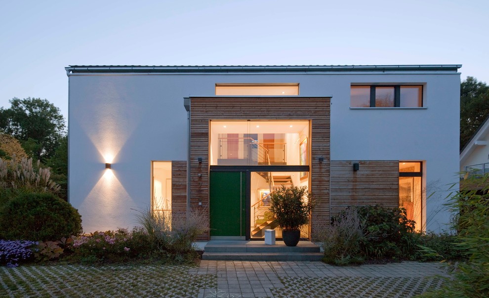 Diseño de puerta principal contemporánea de tamaño medio con paredes marrones, suelo de cemento, puerta simple, puerta verde y suelo gris