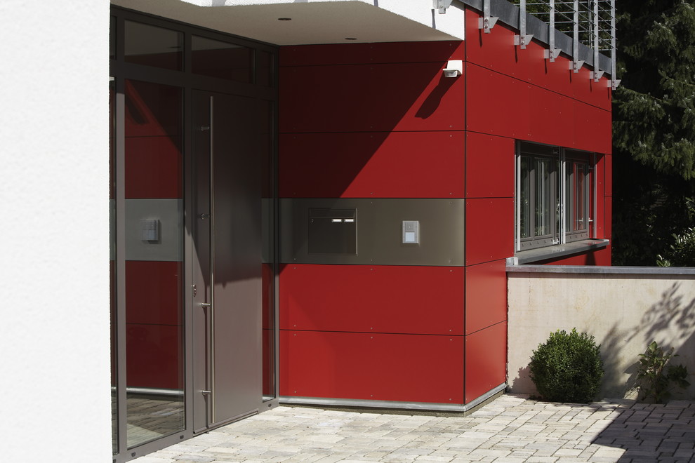 Exemple d'une très grande porte d'entrée tendance avec un mur rouge, un sol en carrelage de céramique, une porte simple, une porte métallisée et un sol gris.